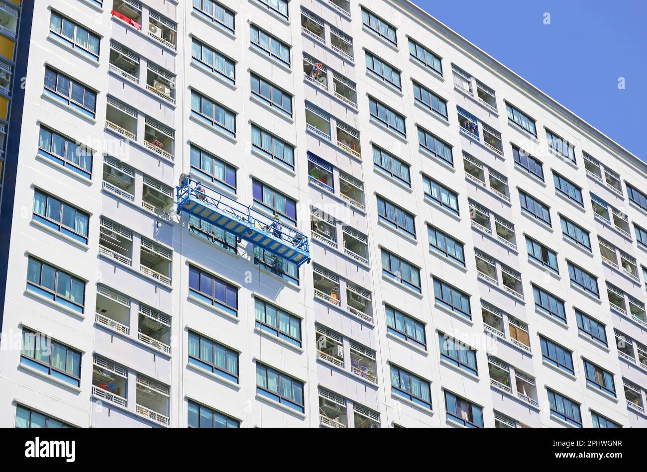 Des ouvriers d'accès à la corde peignant la façade d'un bâtiment moderne de haut niveau Banque D'Images