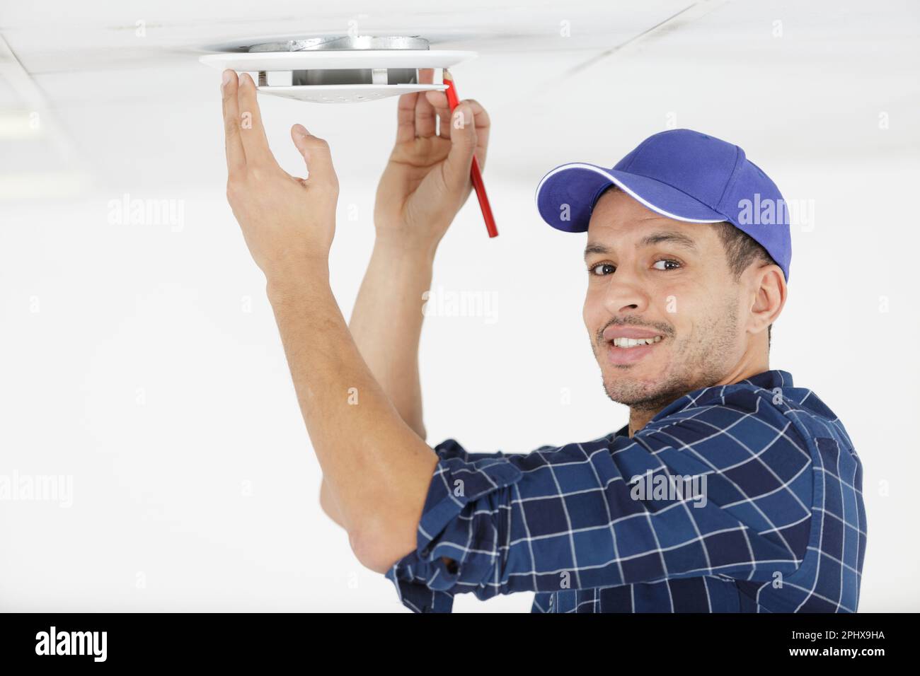 un homme qui effectue des mesures de plafond Banque D'Images