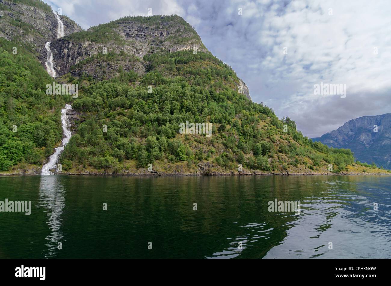 Cascade descendant d'une montagne à l'eau d'un fjord en Norvège Banque D'Images