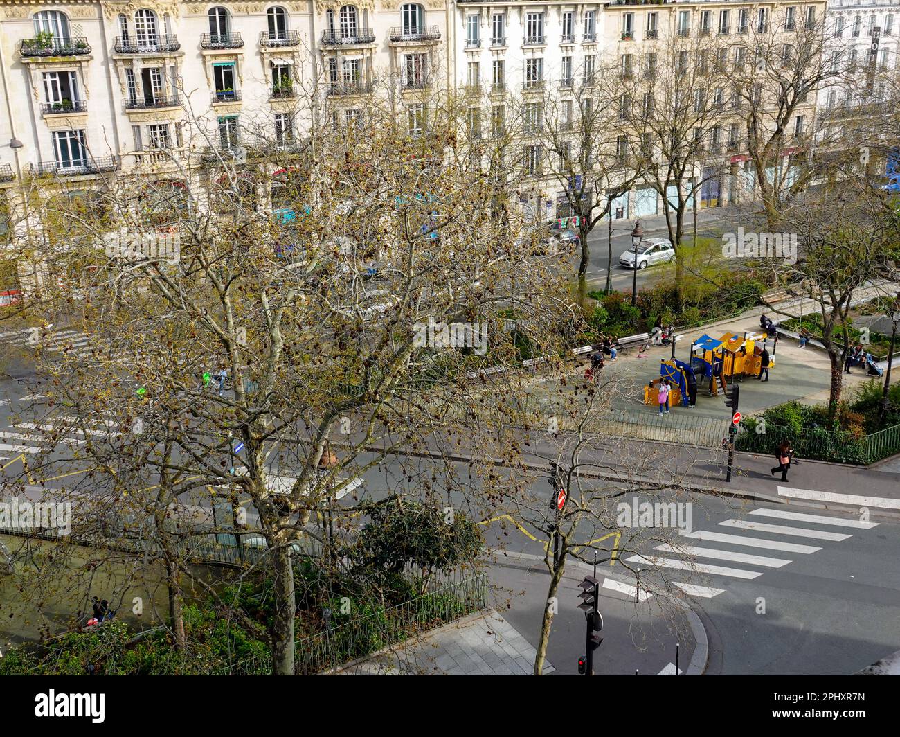 Les enfants sont regardés par les parents, les soignants, pendant qu'ils jouent sur un terrain de jeux de la ville. Tous les jours sur BD Richard-Lenoir, Paris, France. Banque D'Images