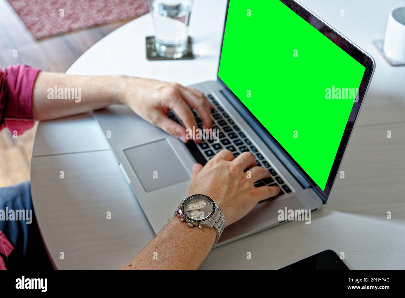 Jeune homme professionnel utilisant un ordinateur portable avec un écran vert - portant une montre de mode. Travail à domicile - Londres, Royaume-Uni, 1st juin 2019 Banque D'Images