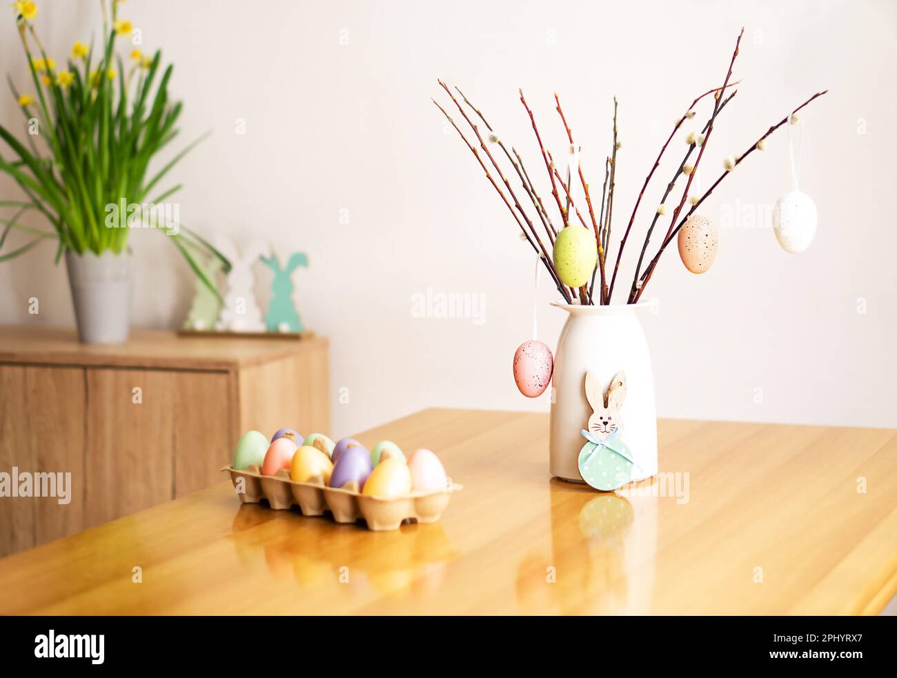 Décoration de Pâques avec un bouquet de branches de saule avec des œufs de couleur, des fleurs et des lapins. Banque D'Images