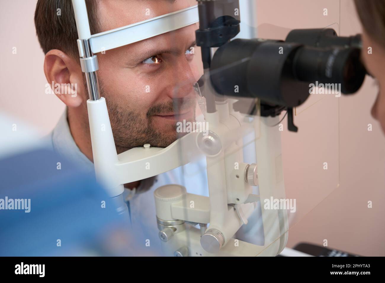 Un homme confiant reçoit une consultation qualifiée en clinique d'ophtalmologie Banque D'Images