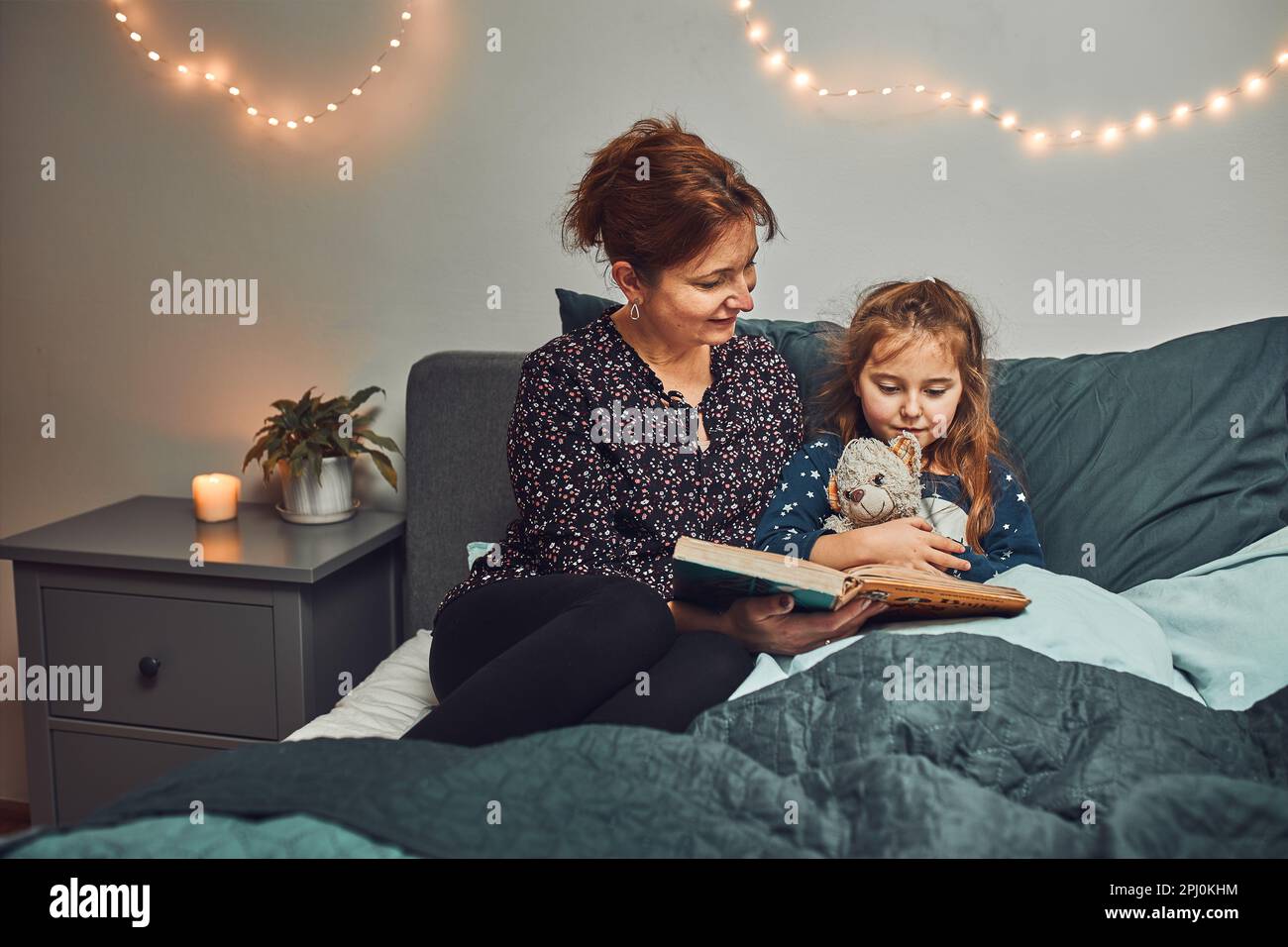 Mère lisant livre sa fille dans le lit avant d'aller dormir. Lire des histoires avant de dormir. Histoires de coucher pour enfant Banque D'Images