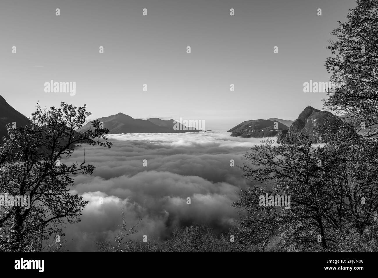 Mountain Peak San Salvatore au-dessus de Cloudscape avec un arbre d'automne et la lumière du soleil avec ciel clair à Lugano, Tessin en Suisse. Banque D'Images