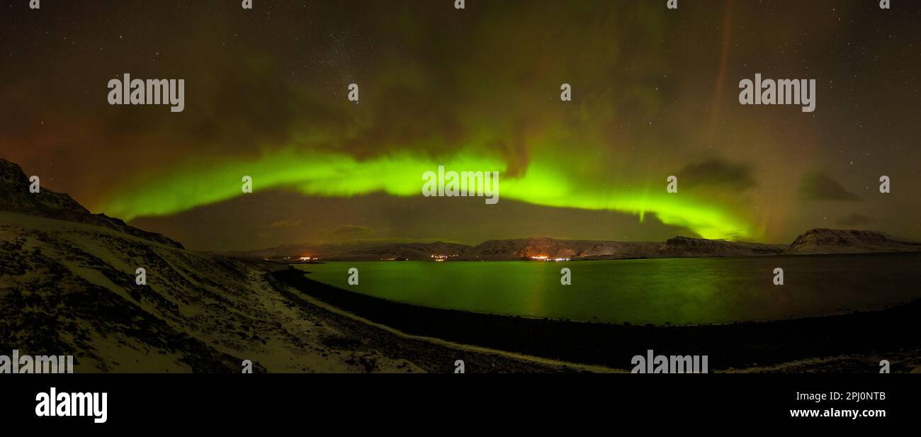 Les aurores boréales, Aurora Borealis au-dessus des eaux de Kollafjörður en Islande, un peu en haut de la côte de Reykjavík, avec les étoiles et les nuages Banque D'Images