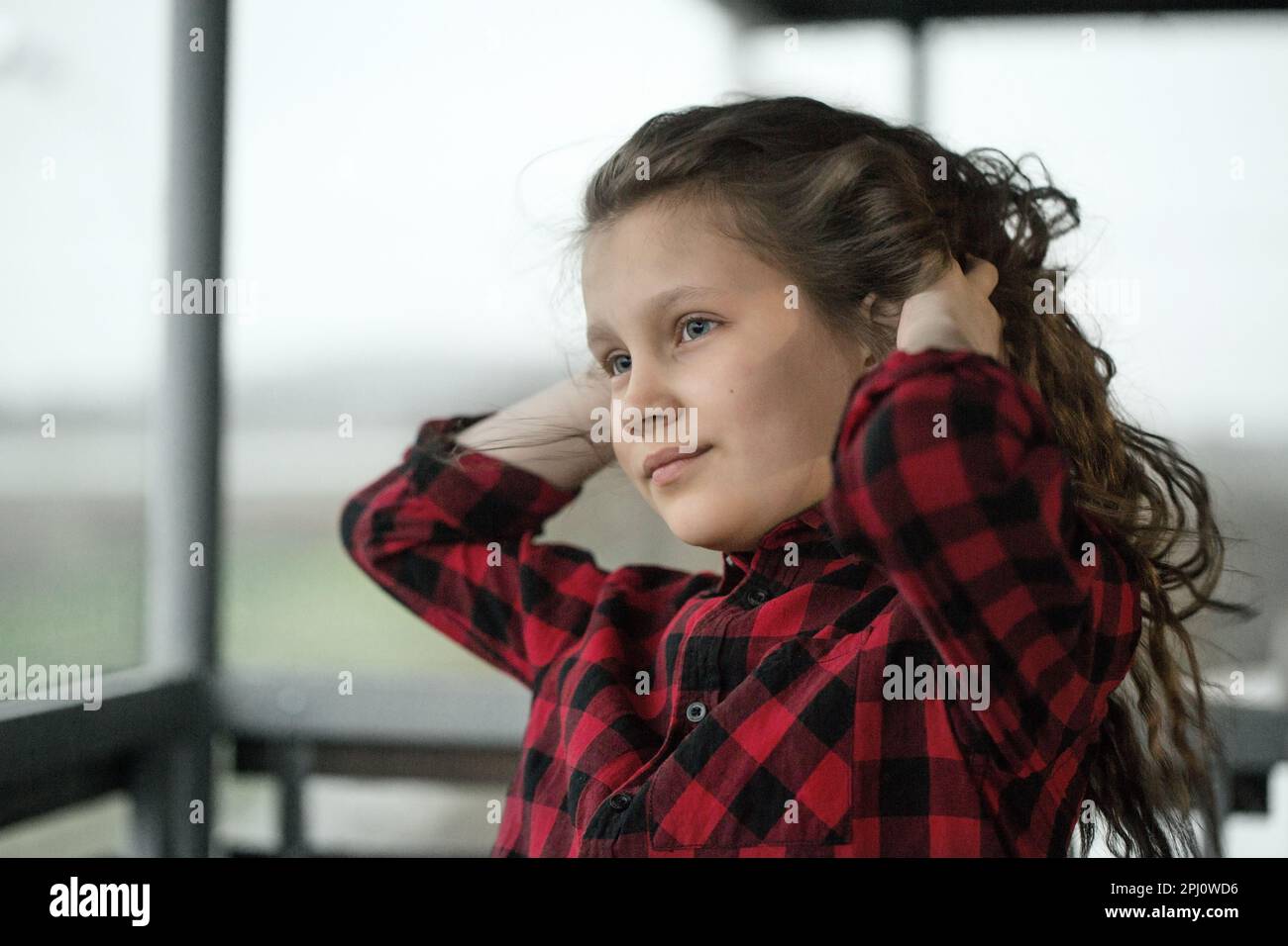 Sympa adolescente avec des cheveux bouclés dehors par temps venteux Banque D'Images
