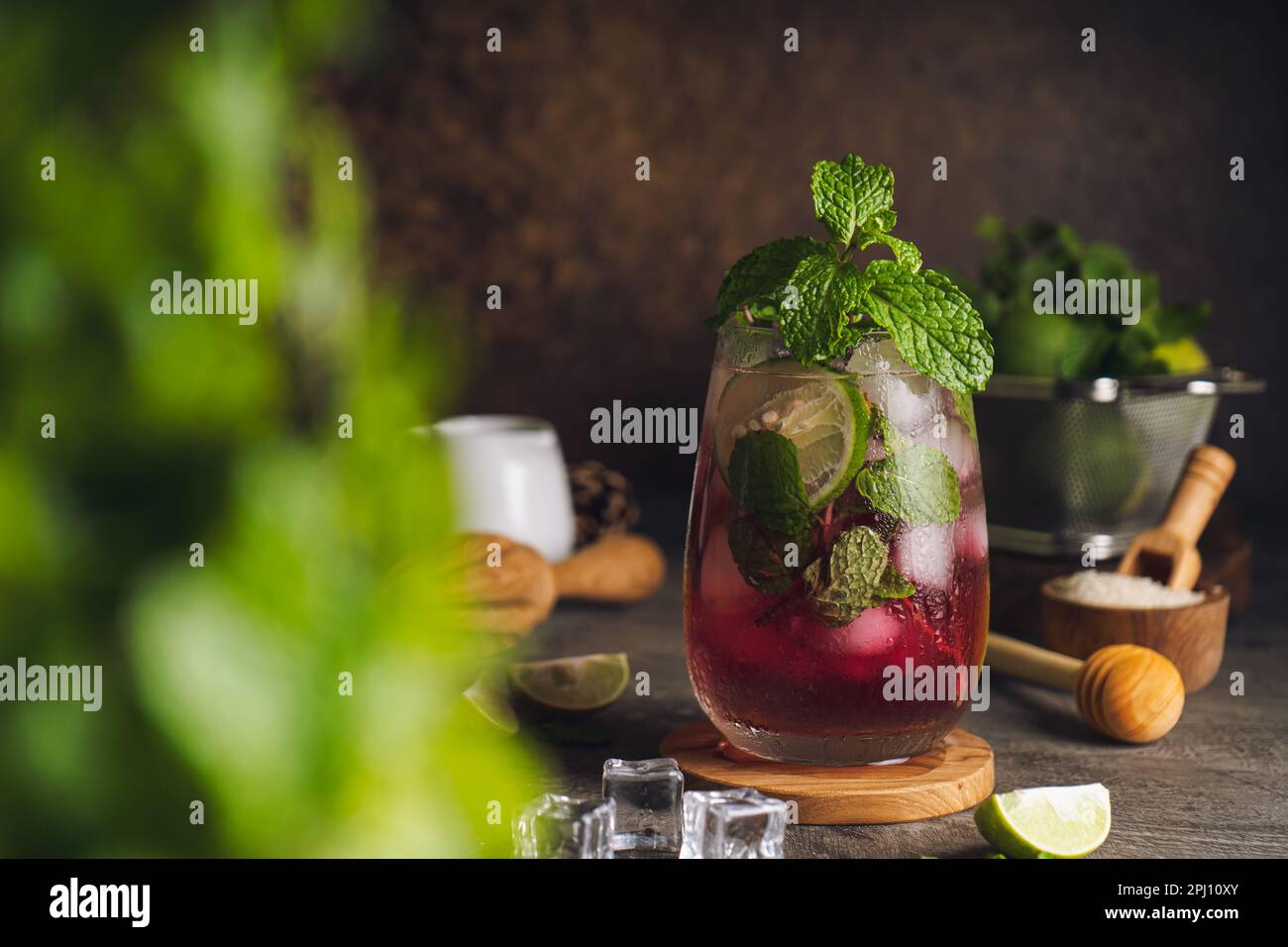 Cocktail mojito d'été aux fraises fraîches avec des cubes de fraise, de lime, de menthe, de rhum et de glace. Banque D'Images