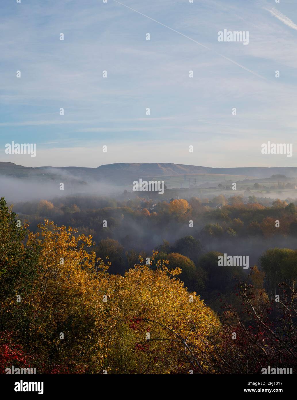 Une vallée de brume matinale, surplombant les sommets des arbres du début de l'automne vers Hayfield et Kinder Scout de New Mills, la nature dans le pic élevé. Banque D'Images