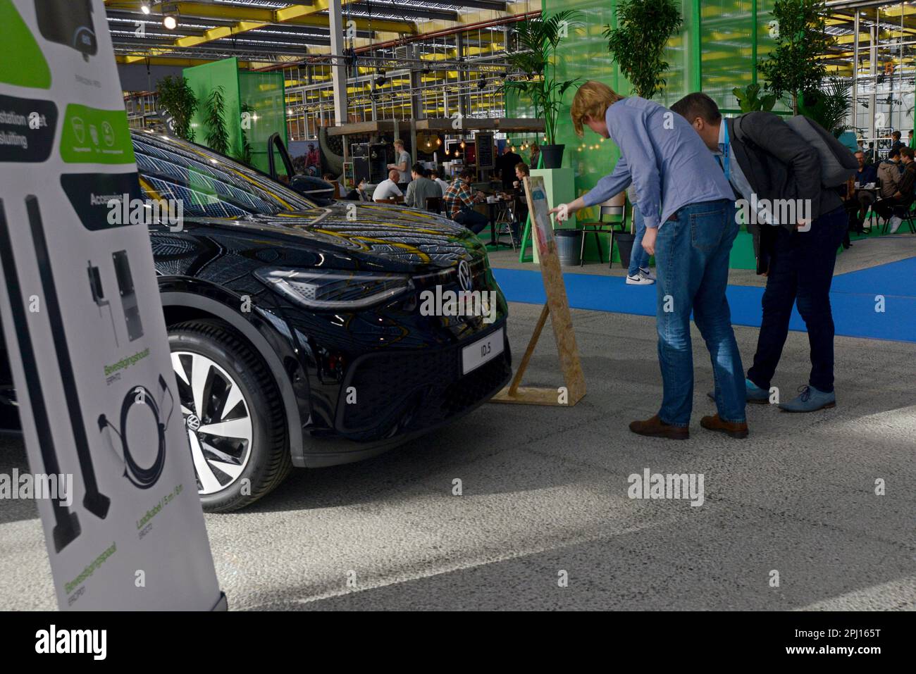 Les personnes qui étudient les voitures électriques Volkswagen exposées au salon World of eMobility Haarlem novembre 2022 Banque D'Images