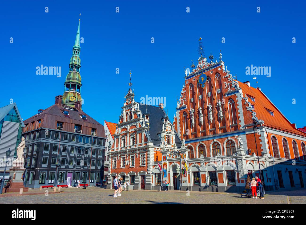 Riga, Lettonie, 24 juin 2022 : place Ratslaukums avec église Saint-Pierre et maison des Blackheads dans la vieille ville de Riga en Lettonie. Banque D'Images