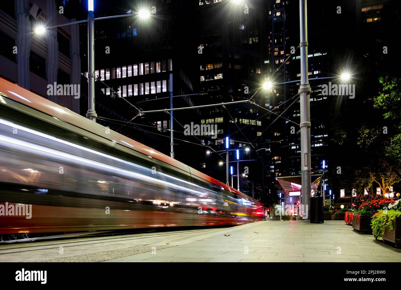 Un train léger à Sydney près de la gare de l'hôtel de ville qui traverse le quartier des affaires ou le centre-ville de Sydney Banque D'Images