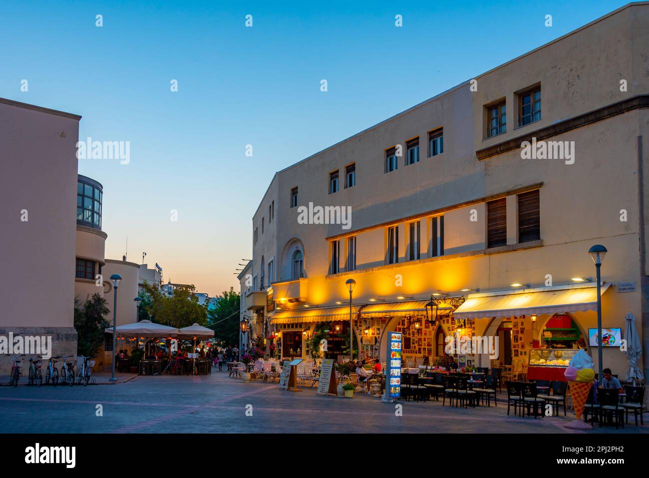 Kos, Grèce, 28 août 2022: Coucher de soleil vue d'une rue touristique dans la ville grecque de Kos. Banque D'Images