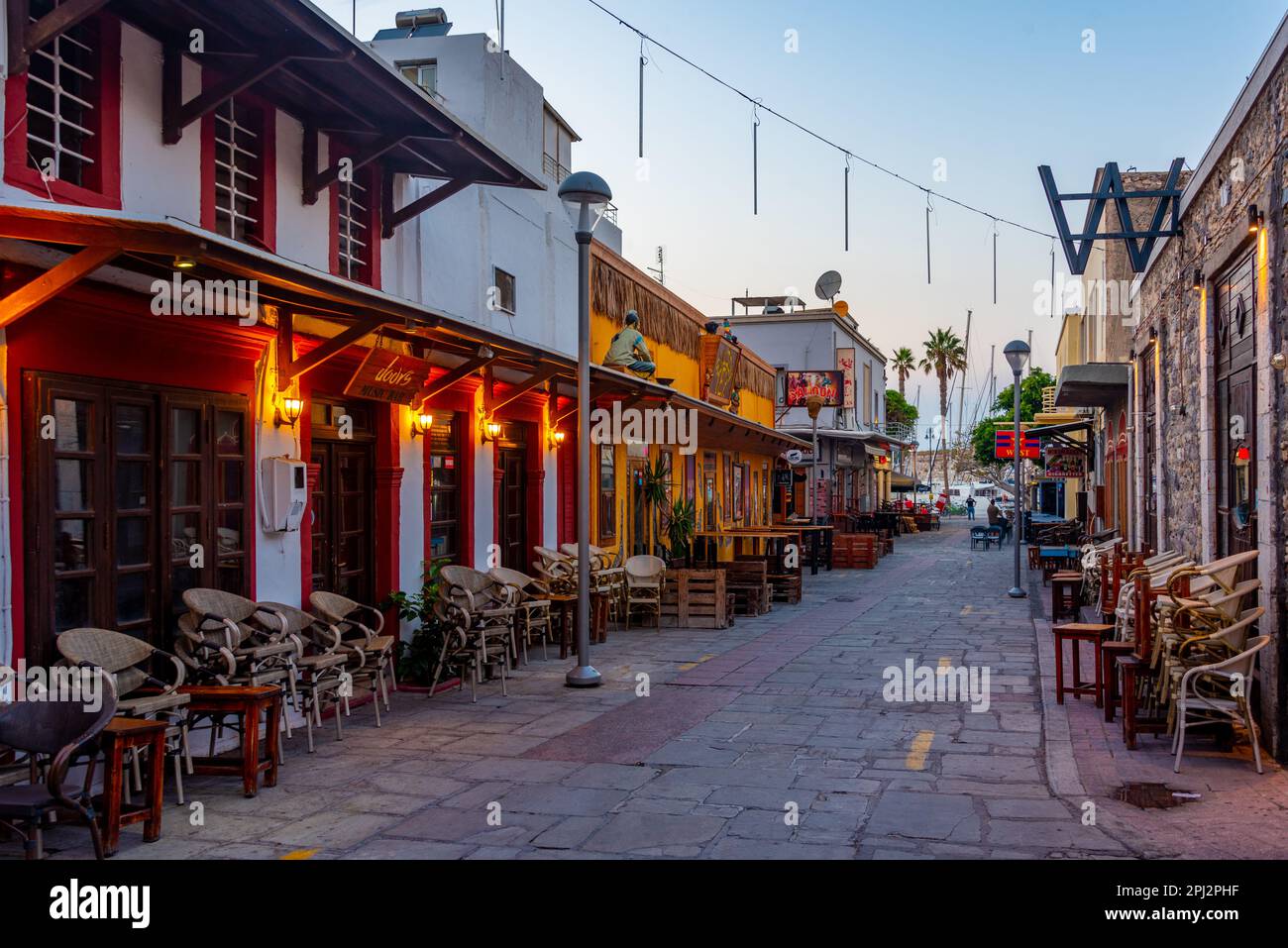 Kos, Grèce, 28 août 2022: Coucher de soleil vue d'une rue touristique dans la ville grecque de Kos. Banque D'Images