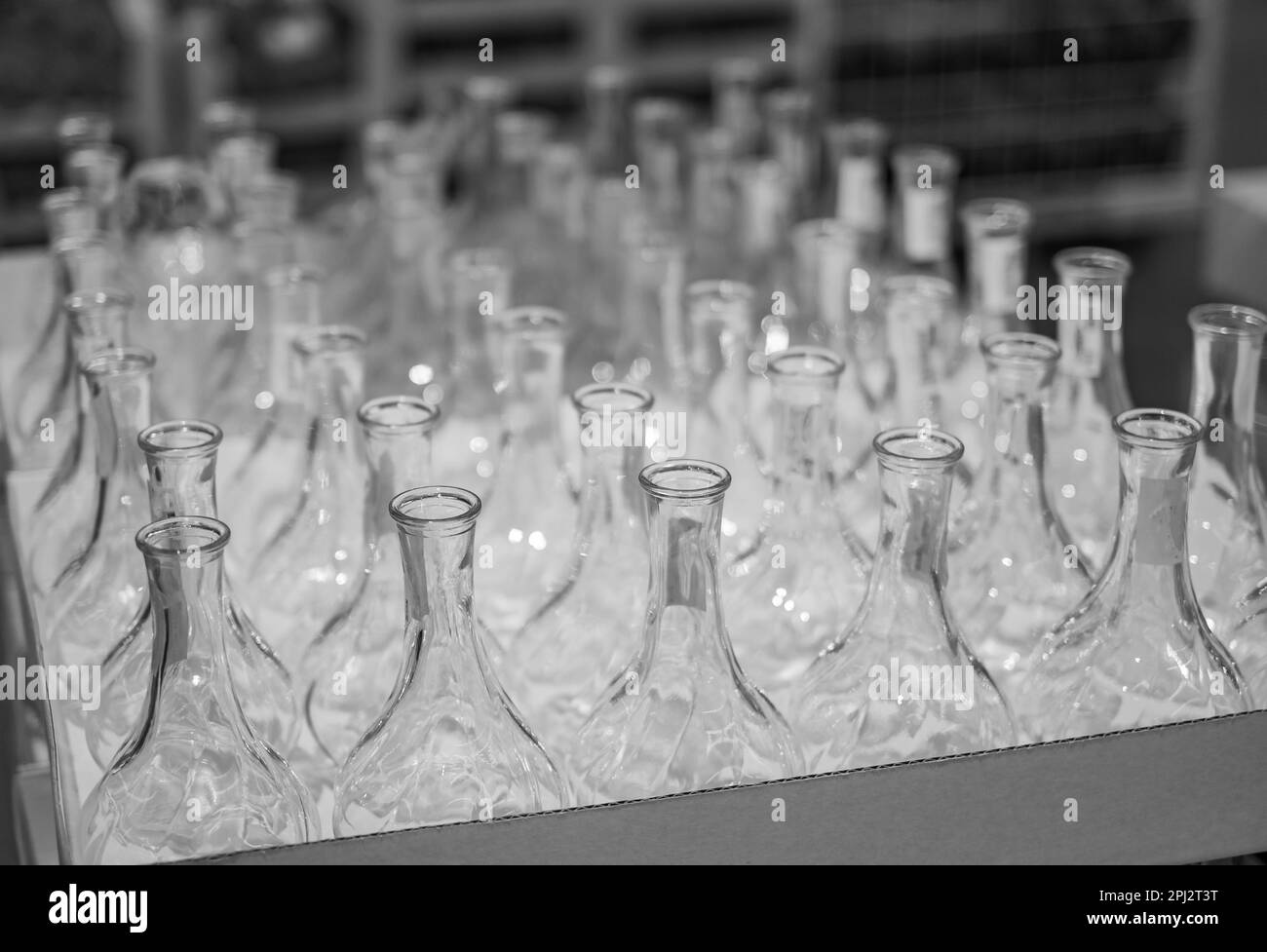 Beaucoup de bouteilles en verre. Flacons en verre transparent dans la boîte. Videz les bouteilles en verre sur la tablette. Personne, flou, mise au point sélective Banque D'Images
