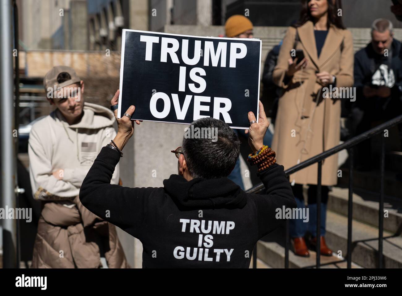 Le protesté contre Trump porte un panneau devant le tribunal pénal de Manhattan pour préparer une possible inculpation de Donald Trump. Banque D'Images