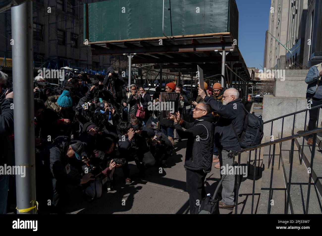 Des manifestants anti-Trump tiennent des panneaux devant le tribunal pénal de Manhattan pour préparer une possible inculpation de Donald Trump. Banque D'Images