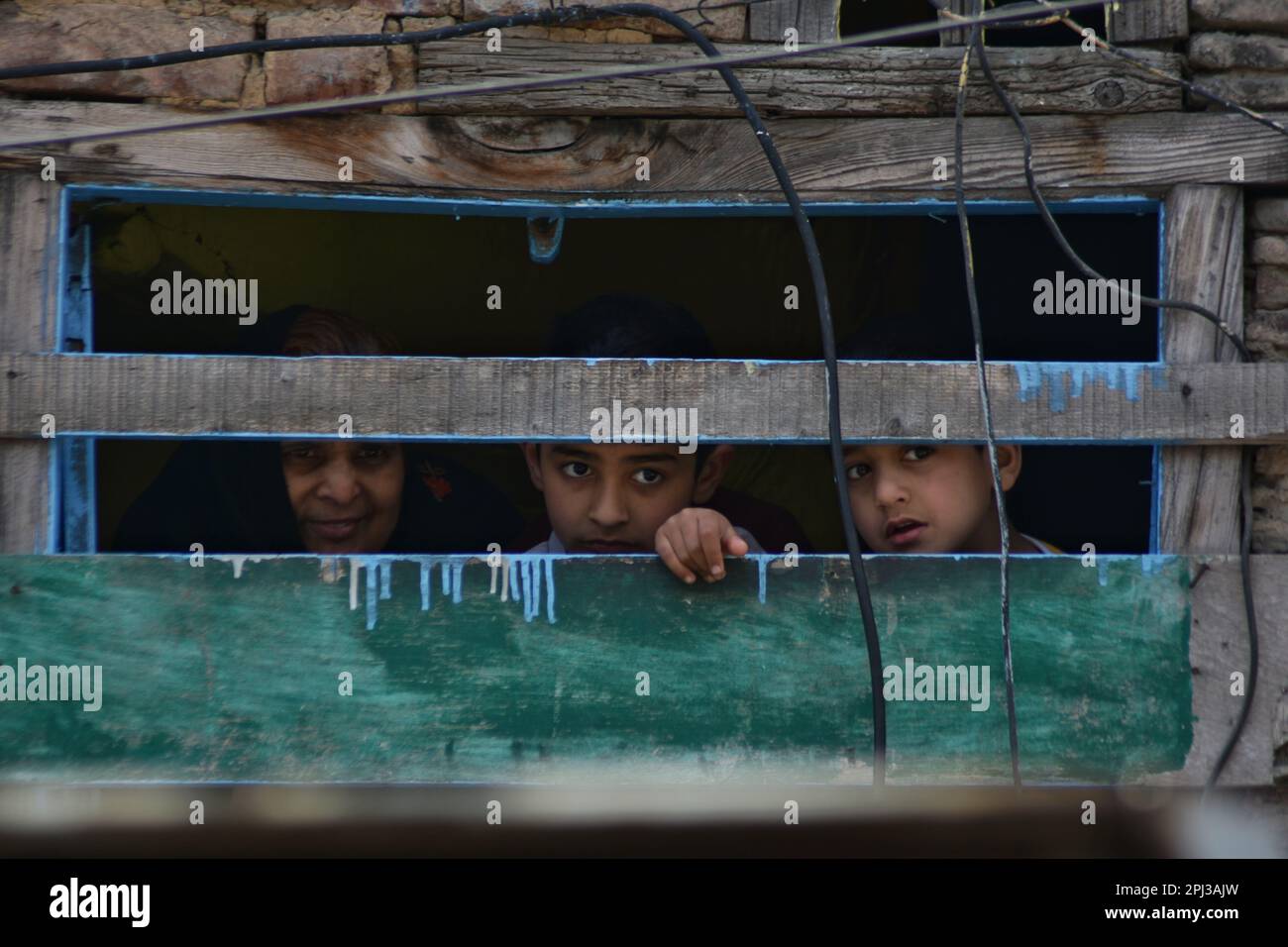 Srinagar, Inde. 30th mars 2023. Une famille regarde de la fenêtre de leur maison que les Hindous de Kashmiri prennent une procession sur le festival RAM Navami à Srinagar, Cachemire contrôlé par l'Inde, jeudi, 30 mars 2023. RAM Navami marque la naissance de Hindou God Rama (photo de Mubashir Hassan/Pacific Press) Credit: Pacific Press Media production Corp./Alay Live News Banque D'Images