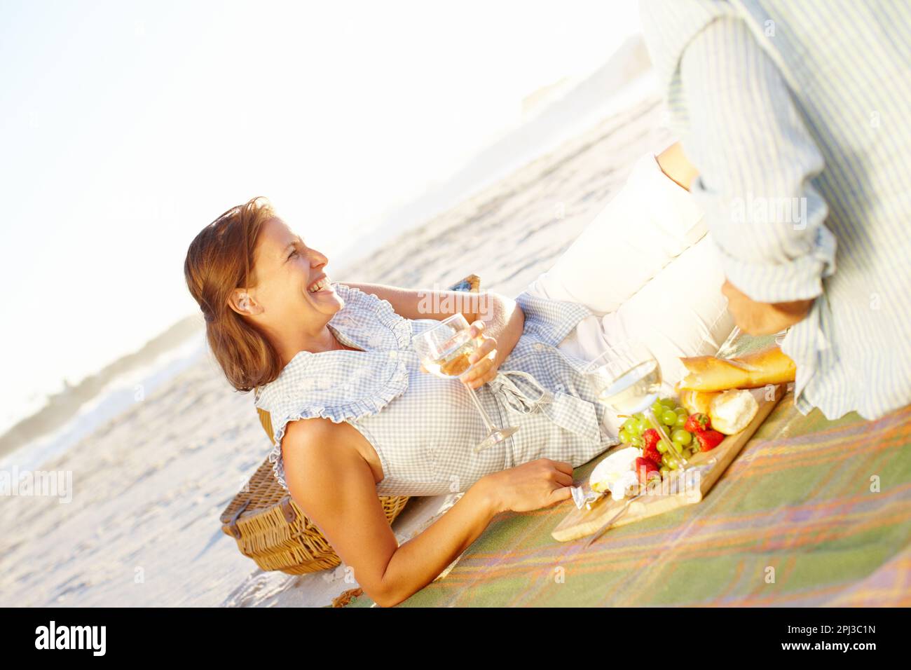 Vin et pique-nique romantique. Une heureuse femme mûre se détendant sur une  couverture de pique-nique et appréciant le coucher du soleil avec son mari  Photo Stock - Alamy