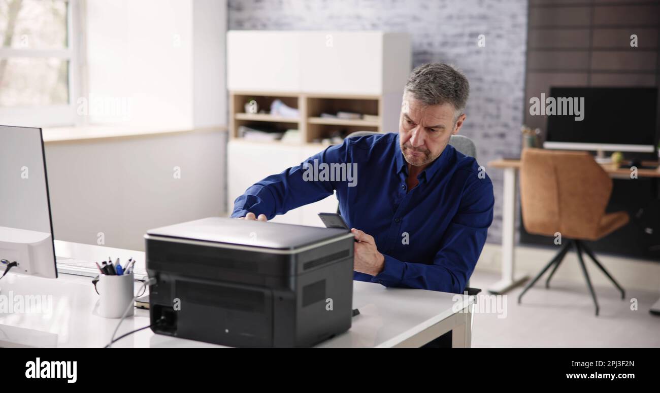 Homme d'affaires donnant la commande d'impression sur Smart Phone au bureau Banque D'Images
