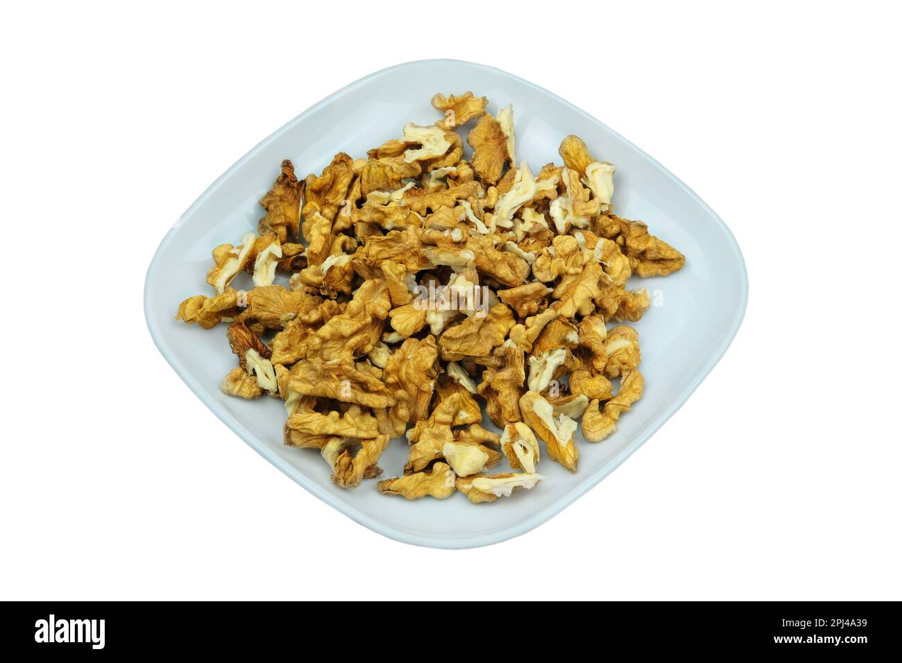 Noix dans un plat isolé sur fond blanc. Noyaux de noyer. Banque D'Images