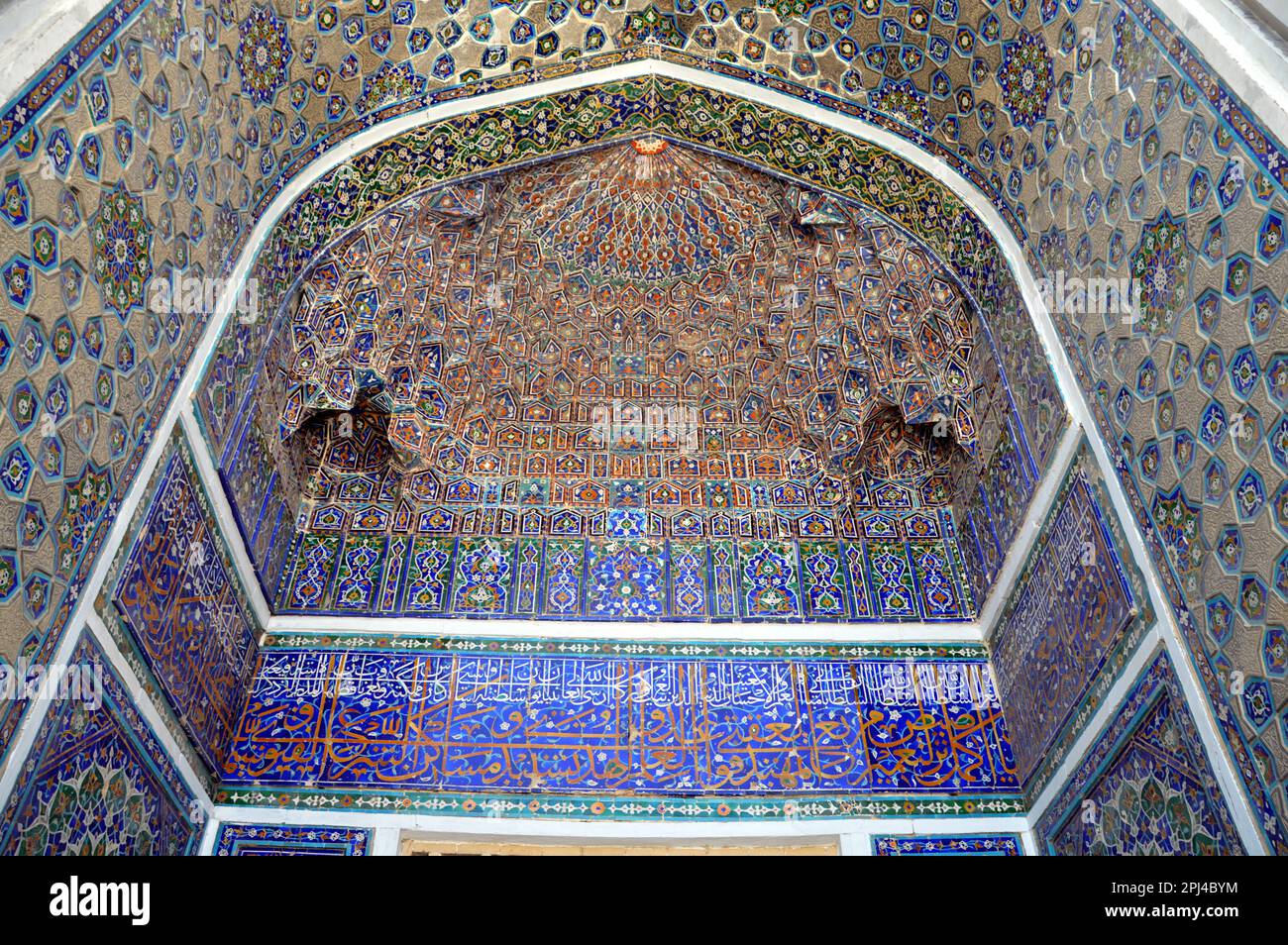 Ouzbékistan, Samarkand, Registan: iwan coloré avec des 'stalactites' et des bandes de calligraphie dans la madrasa de Baugh, construite 1417-20. Banque D'Images