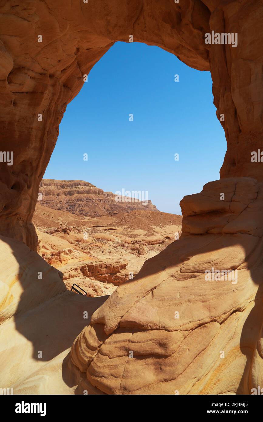 C'est le paysage du désert d'Arava en Israël à travers une fenêtre en pierre érosive dans la roche. Banque D'Images