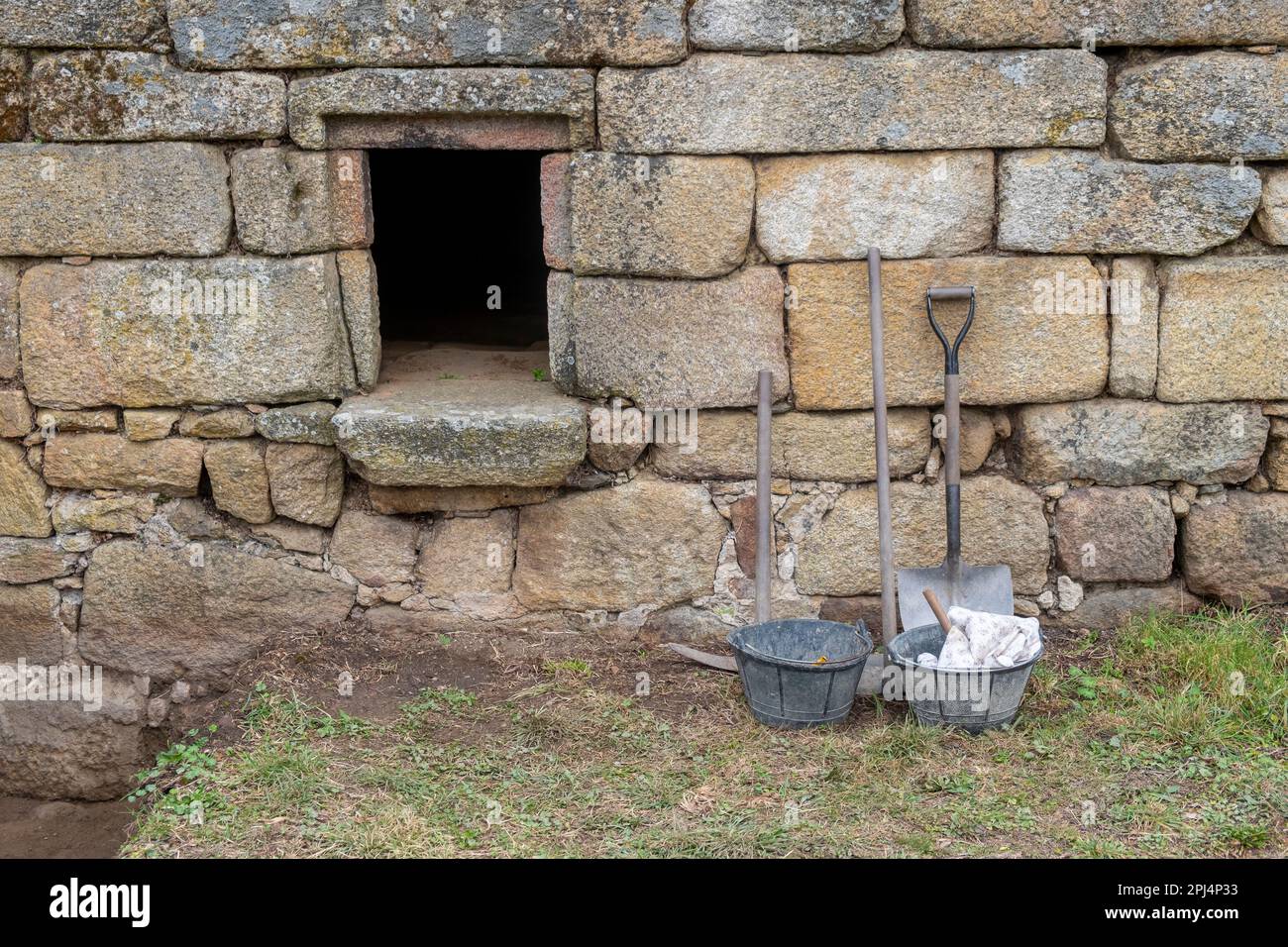 outils à côté d'un ancien mur de pierre dans une excavation archéologique. Banque D'Images