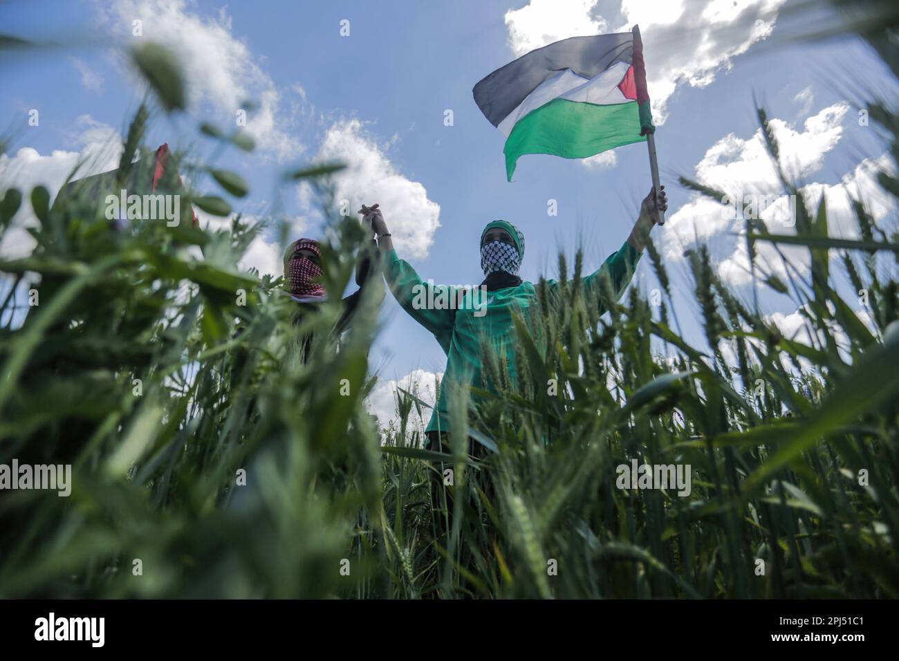 Les Palestiniens détiennent des drapeaux lors d'une manifestation marquant la « Journée de la terre » le long de la frontière entre Israël et la bande de Gaza, dans l'est de la bande de Gaza. La journée commémore les événements du 30 mars 1976, lorsque des marches et une grève générale ont été organisées dans les villes arabes contre la décision du gouvernement israélien d'exproprier de grandes parcelles de terres palestiniennes pour être colonies. L'événement annuel appelle au droit palestinien de retourner sur les terres dont ils ont été déplacés après la création d'Israël en 1948. (Photo de Mahmoud Issa/SOPA Images/Sipa USA) Banque D'Images