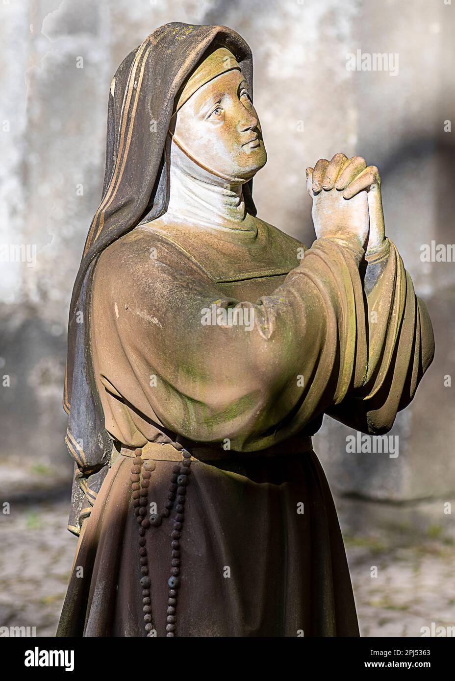 Toujours dans la prière, mais sculpté dans la pierre, une nonne figée à jamais dans la dévotion Banque D'Images
