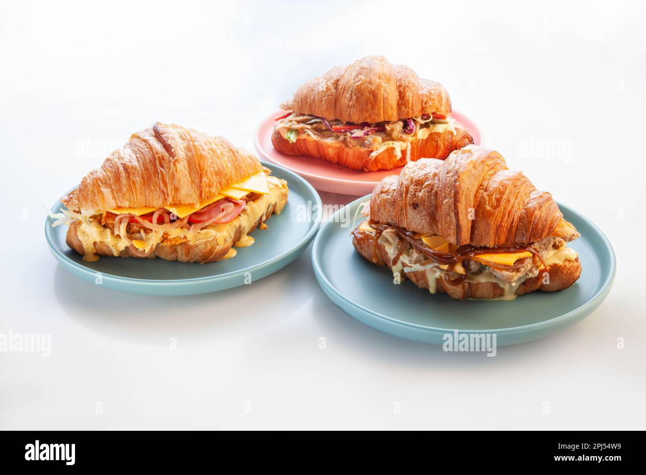 Croissants à la brioche servis dans des assiettes bleues. Banque D'Images
