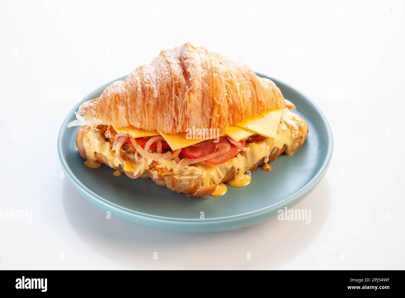 Sandwich au poulet croissant brioche sur fond blanc bleu. Banque D'Images
