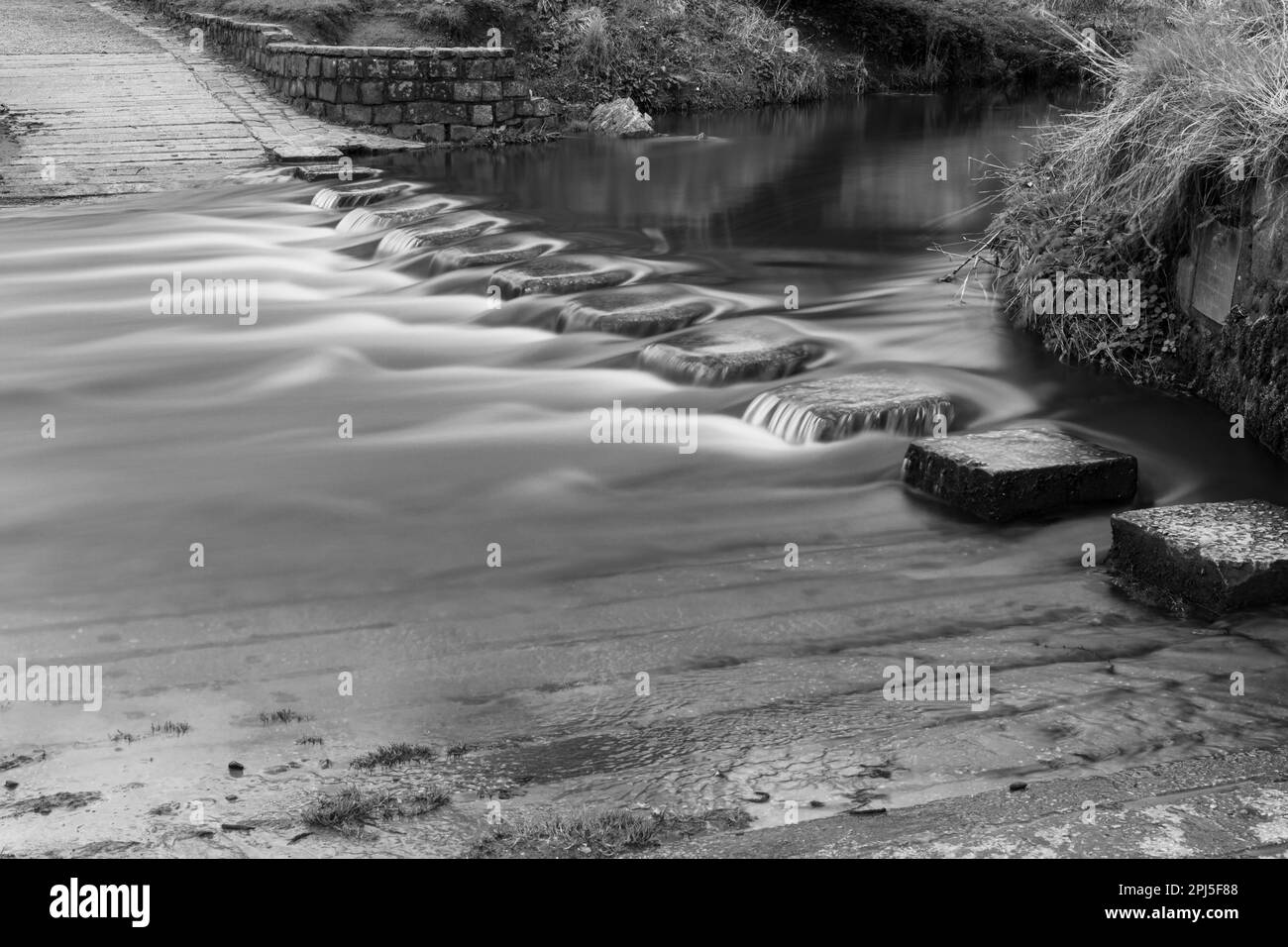 Eau noir et blanc qui coule sur le déversoir de longues expositions Banque D'Images