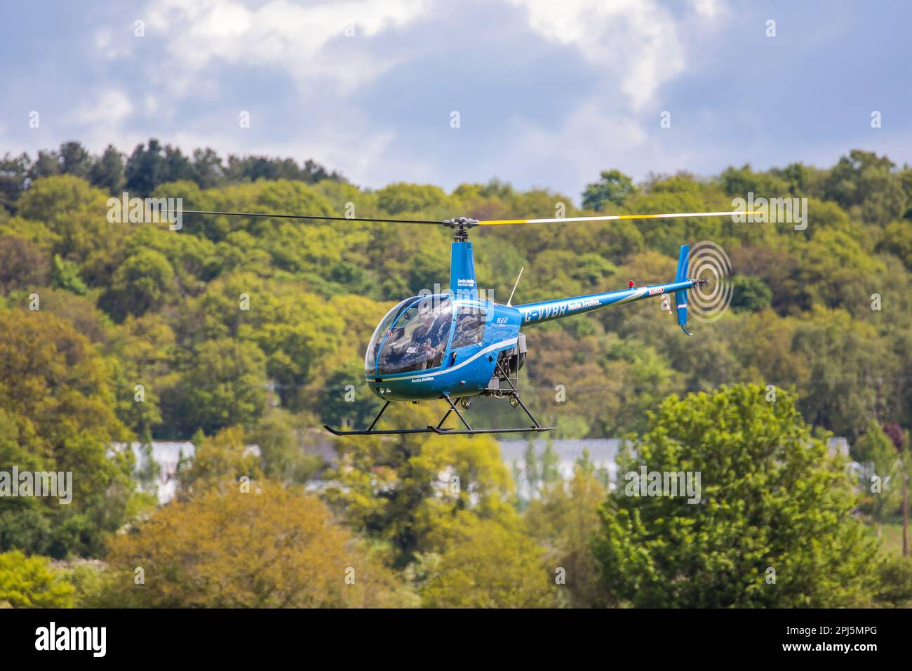 Cours d'aviation: Hélicoptère bleu volant isolé à l'aéroport de Halfpenny Green, nr. Wolverhampton, West Midlands, Royaume-Uni. Banque D'Images
