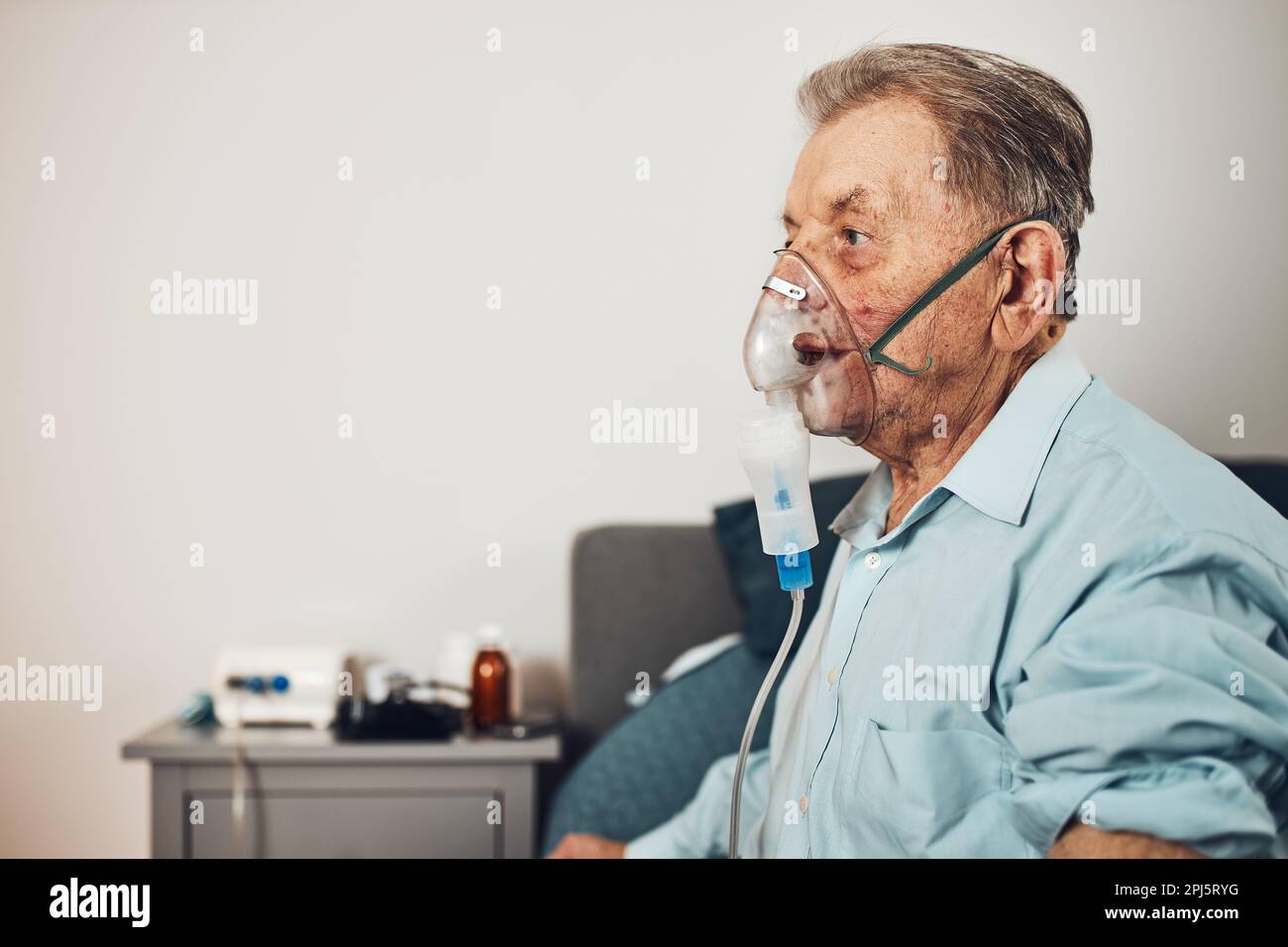 Homme âgé inhalant des voies respiratoires et des poumons appliquant des médicaments. Traitement Covid-19 ou coronavirus. Homme respirant à travers le masque facial à l'aide d'un nébuliseur Banque D'Images