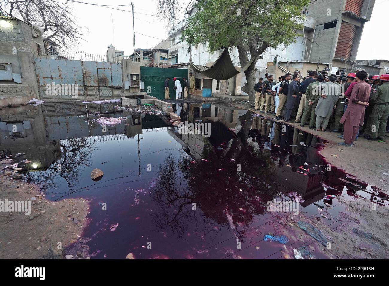 Police officers and members of media gather at the site of stampede, in Karachi, Pakistan, Friday, March 31, 2023. Several people were killed in the deadly stampede at a Ramadan food distribution center outside a factory in Pakistan's southern port city of Karachi, police and rescue officials said. (AP Photo/Fareed Khan) Banque D'Images