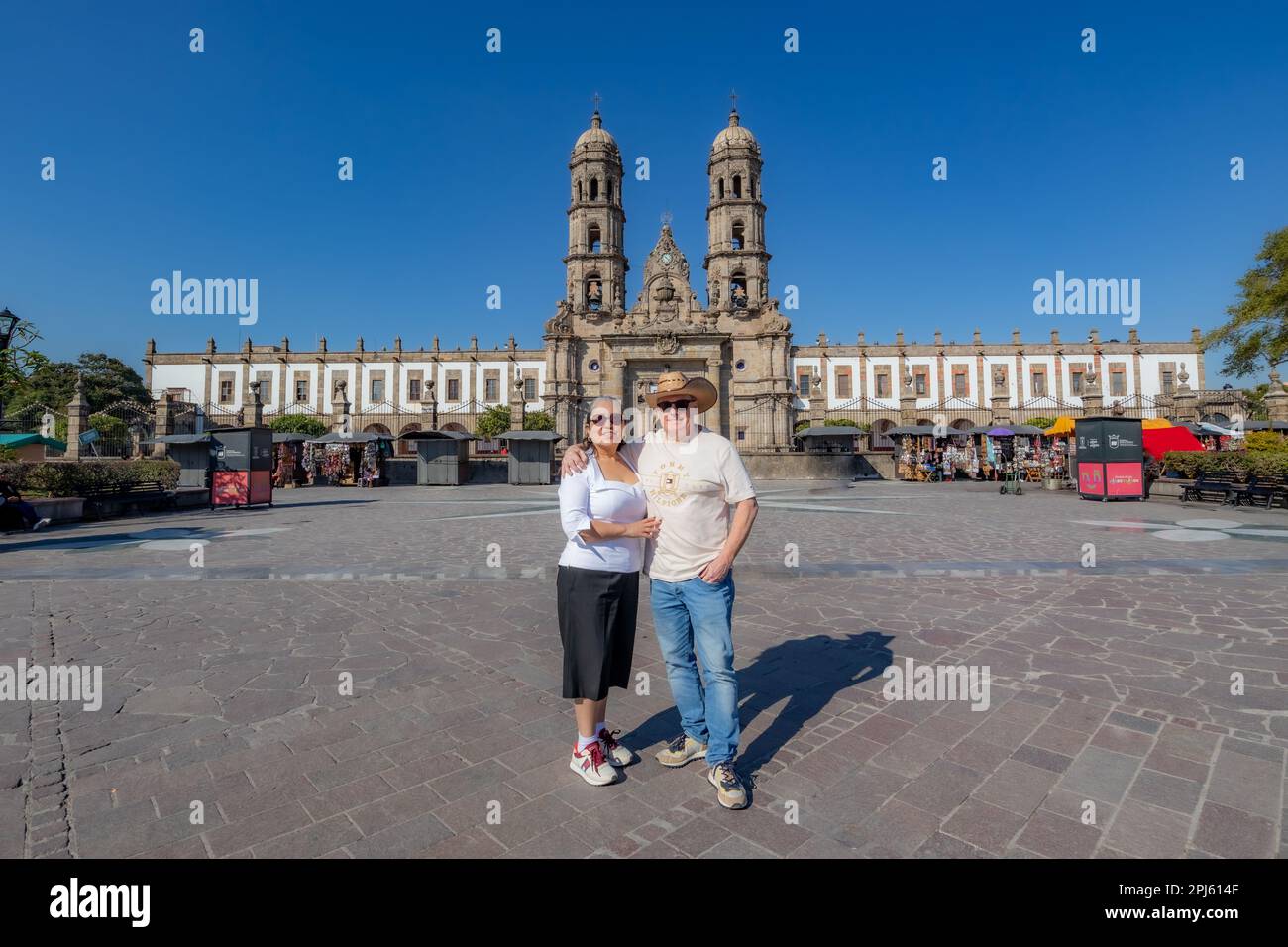 Zapopan, Jalisco Mexique. 7 janvier 2023. Couple de touristes hollandais debout sur la Plaza de las Americas avec la basilique de notre dame en arrière-plan bleu Banque D'Images
