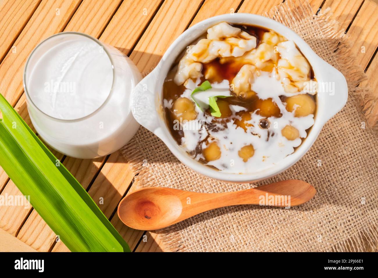 Bubur Sumsum ou Candil porridge, farine de riz indonésienne porridge avec des boules de riz sucrées de patate douce, servi avec de la sauce au sucre de palme dans un bol blanc Banque D'Images