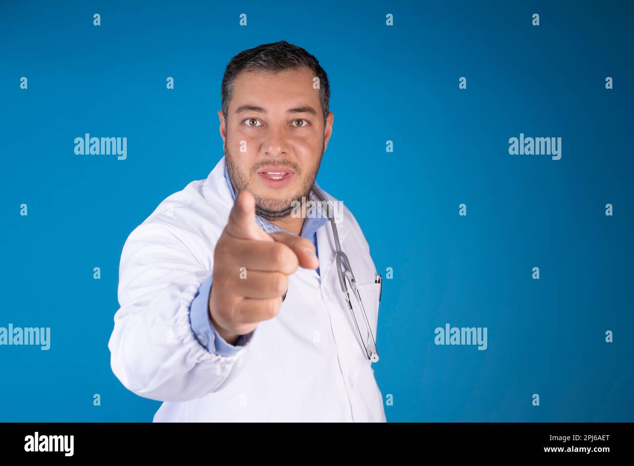 médecin pointant avec son index gros plan sur fond bleu. concept de prescription médicale Banque D'Images