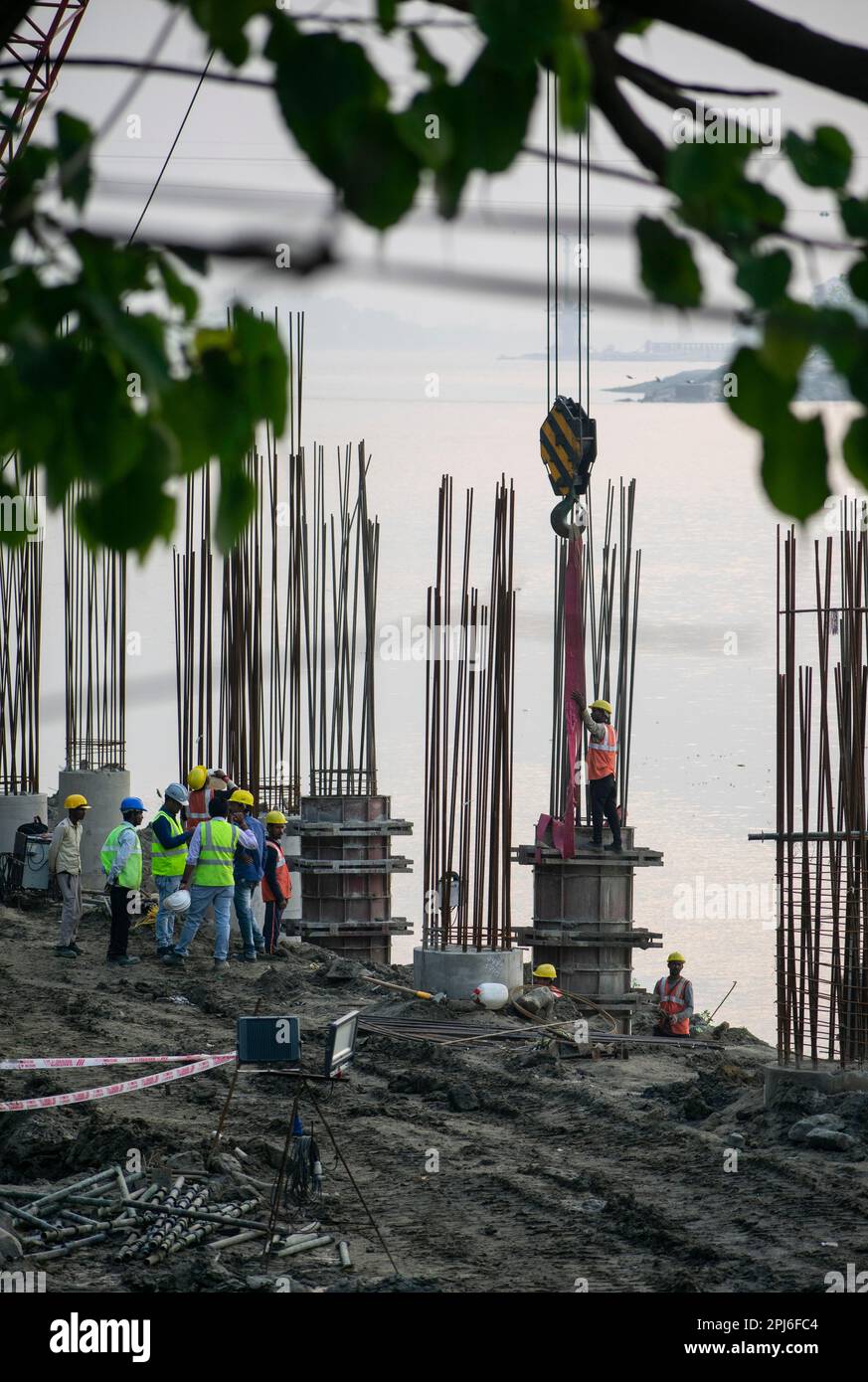 Guwahati, Inde. 27 mars 2023. Les ouvriers de la construction se sont occupés à fabriquer un poteau en béton près de la rivière Brahmaputra à Guwahati Banque D'Images