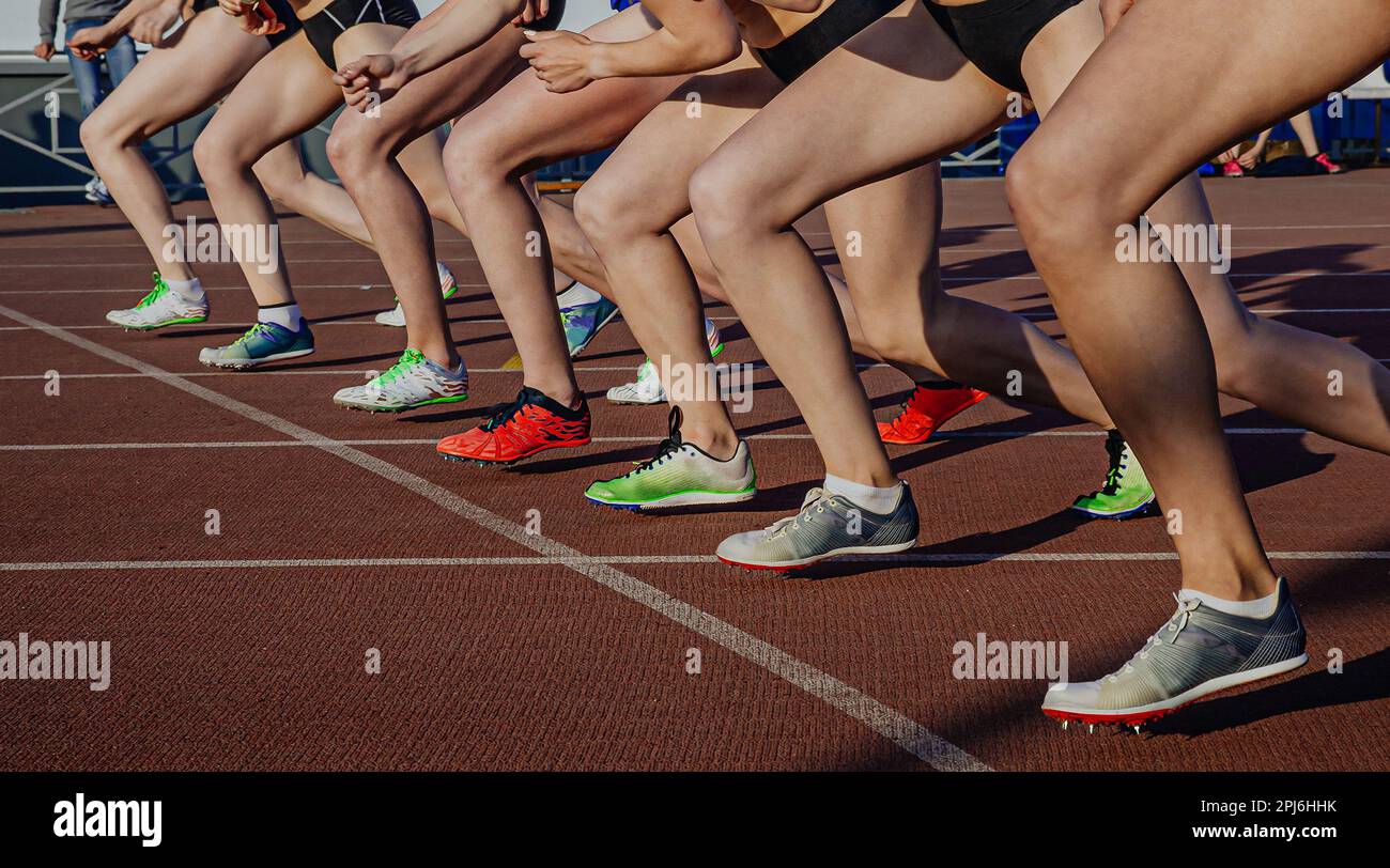 jambes des athlètes féminines en chaussures de course à pied à pointes sur la ligne de départ de la course de distance moyenne, sports olympiques d'été Banque D'Images