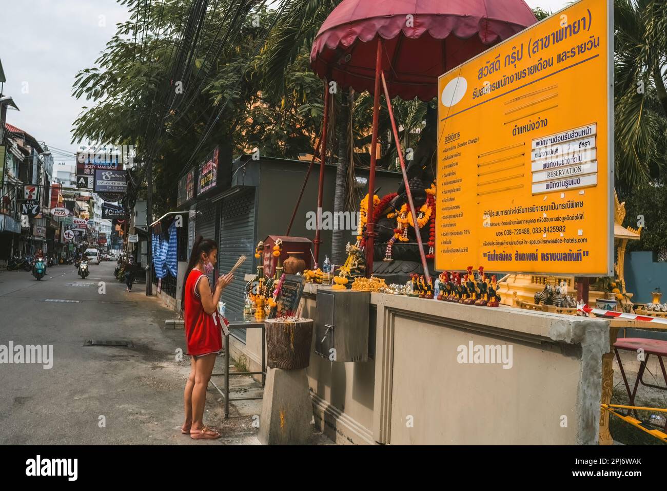 Pattaya,Thaïlande - 15 octobre,2022:soi Buakhao Une jeune femme thaïlandaise priait devant un petit sanctuaire du bouddhisme. Banque D'Images