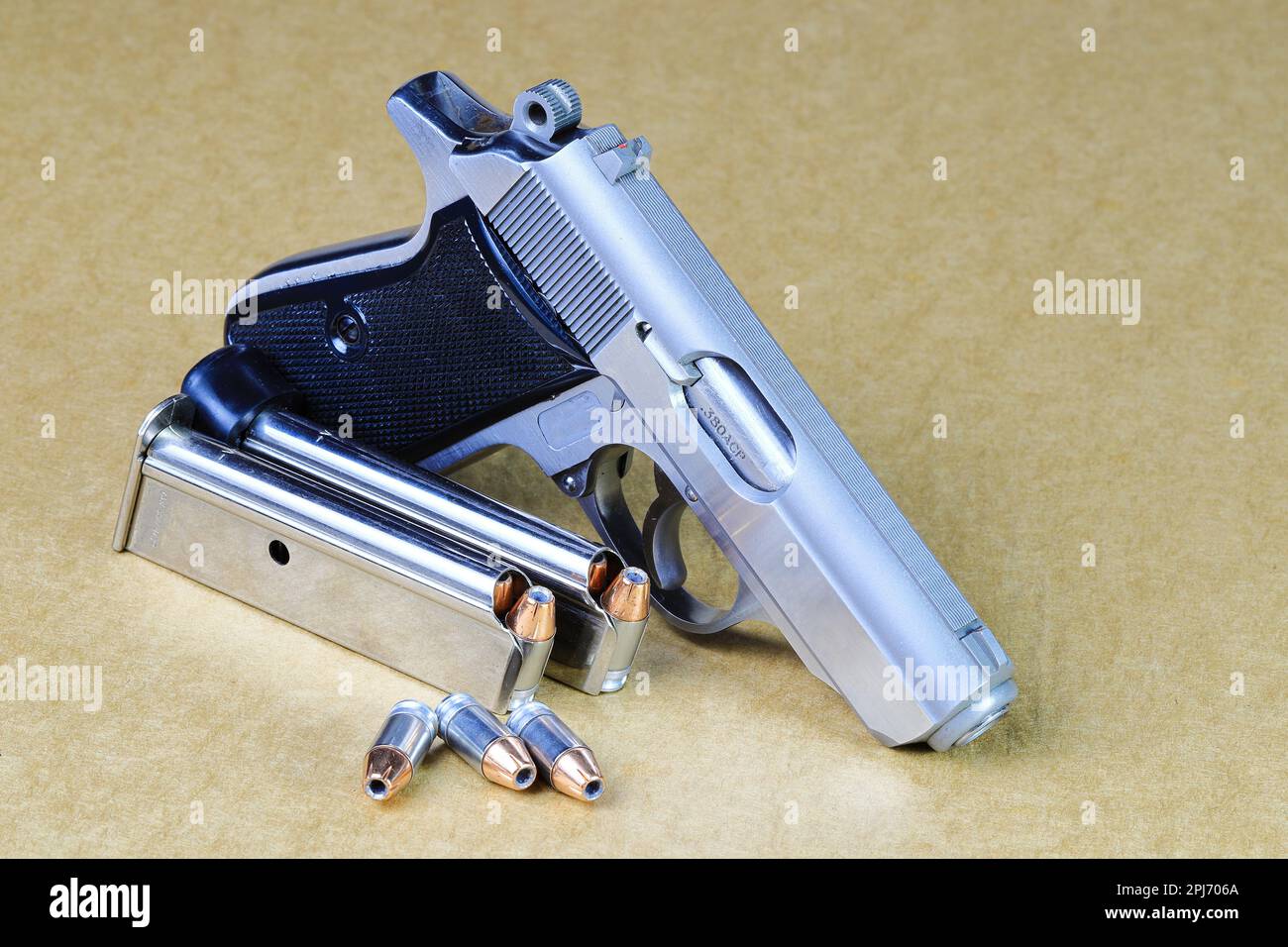 Pistolet semi-automatique compact, pistolet PPK en acier inoxydable avec magasins de rechange, vue latérale droite, prêt à l'emploi, isolé sur fond blanc Banque D'Images