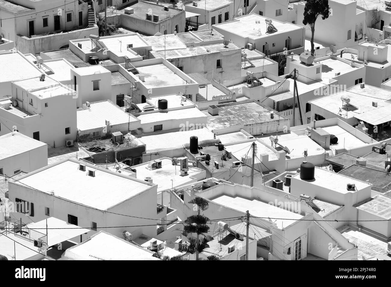 Vue d'en haut sur les bâtiments et maisons résidentiels blanchis à la chaux d'iOS Grèce, en noir et blanc Banque D'Images