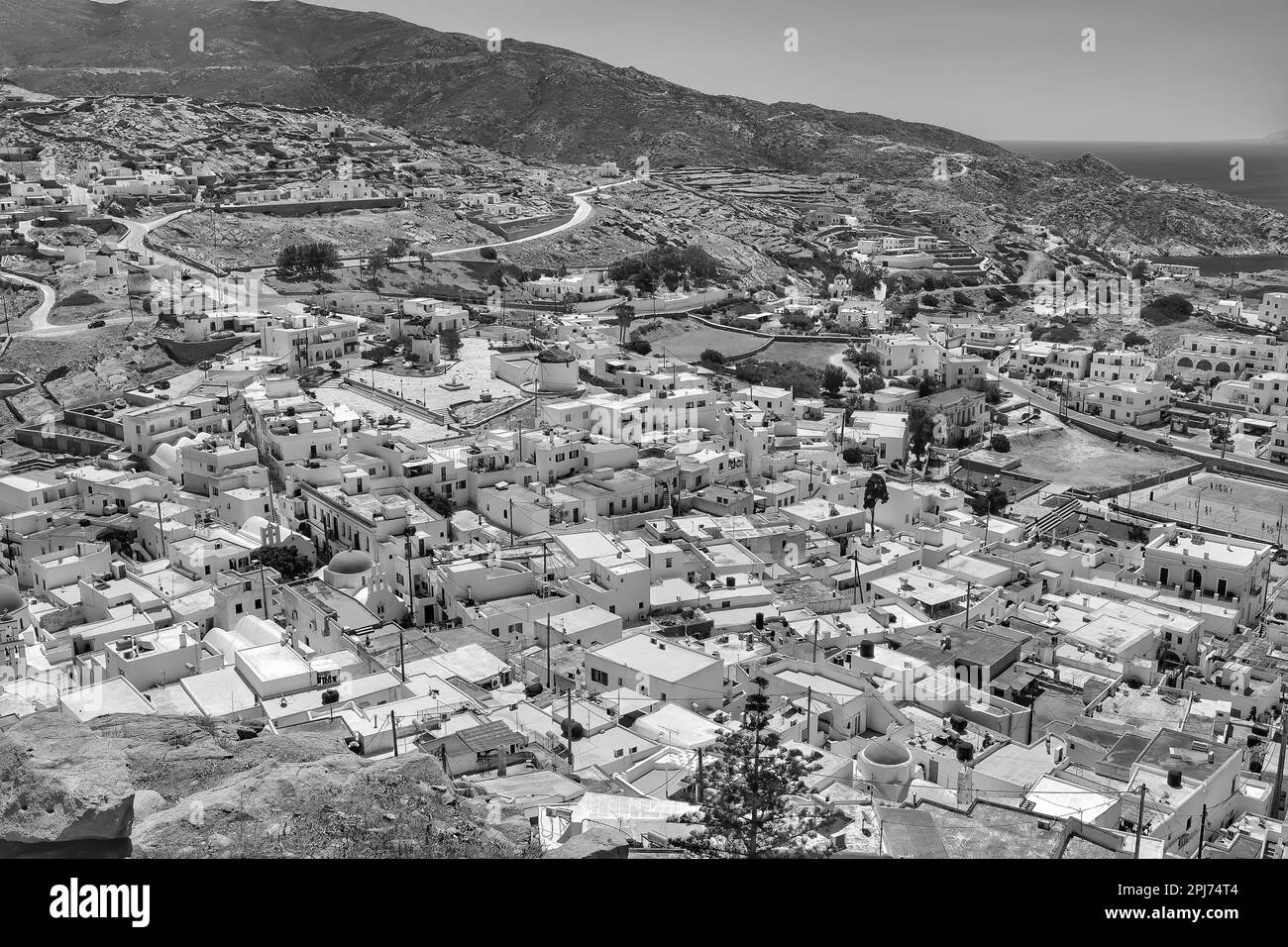 Vue panoramique sur les bâtiments et maisons résidentiels blanchis à la chaux d'iOS Grèce depuis un point de vue en noir et blanc Banque D'Images