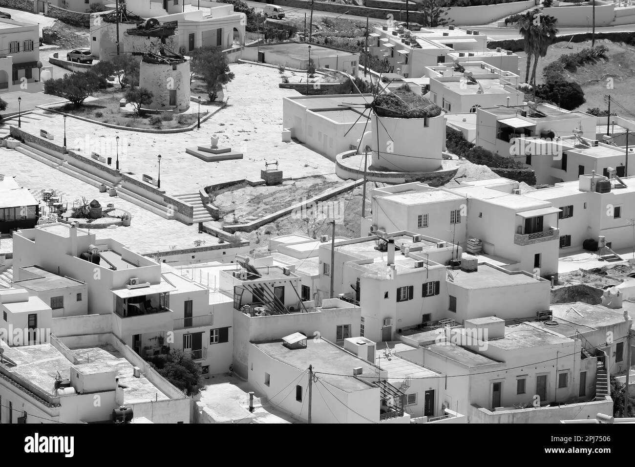 Vue d'en haut sur les bâtiments résidentiels blanchis à la chaux, les anciens moulins à vent et les maisons d'iOS Grèce, en noir et blanc Banque D'Images