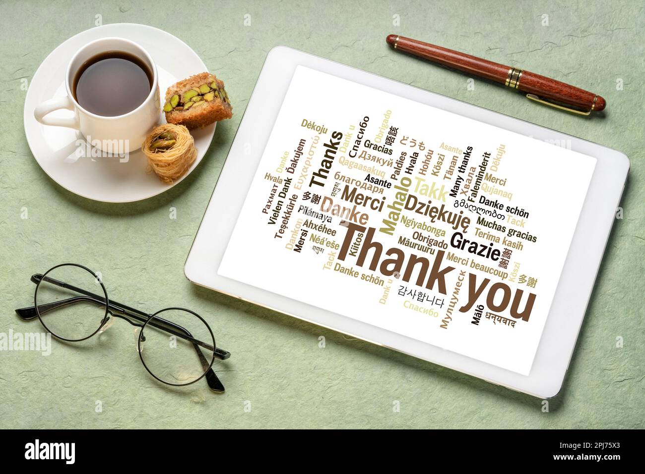 merci dans différentes langues - nuage de mot sur une tablette numérique avec une tasse de café Banque D'Images