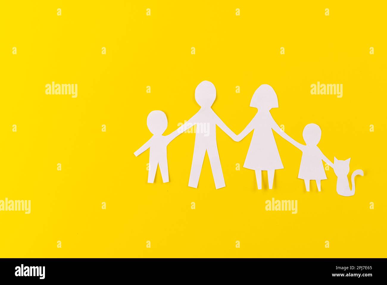 Livre blanc découpé de la famille avec deux enfants et ca et espace de copie sur fond jaune Banque D'Images
