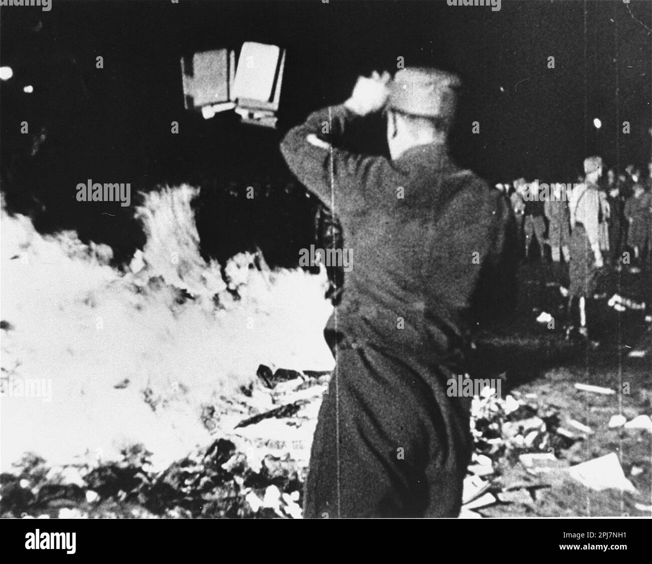 Un homme de sa lance un livre sur un feu à un livre brûlant à Berlin, le 10 mai 1933 Banque D'Images