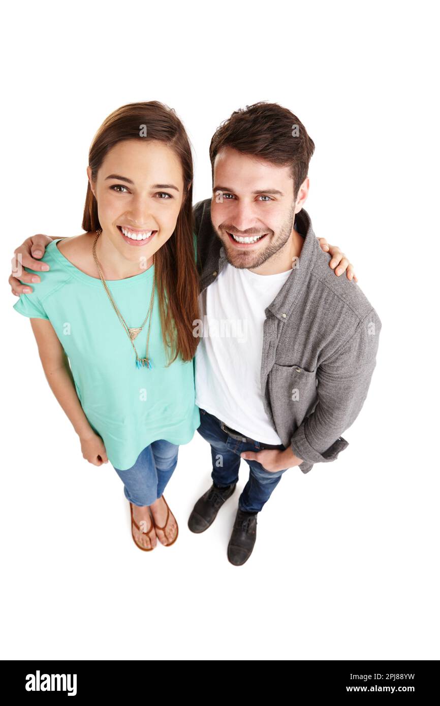 Heureux d'être ensemble. Portrait en grand angle d'un jeune couple heureux se posant sur un fond blanc. Banque D'Images